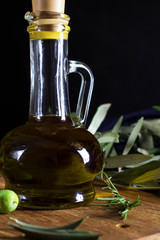 Olive oil in a bottle, vertical, front view, dark photo