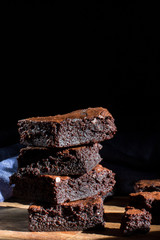 Chocolate brownie on the black background, side view, selective focu