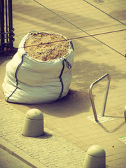 Bag of sand on sidewalk.