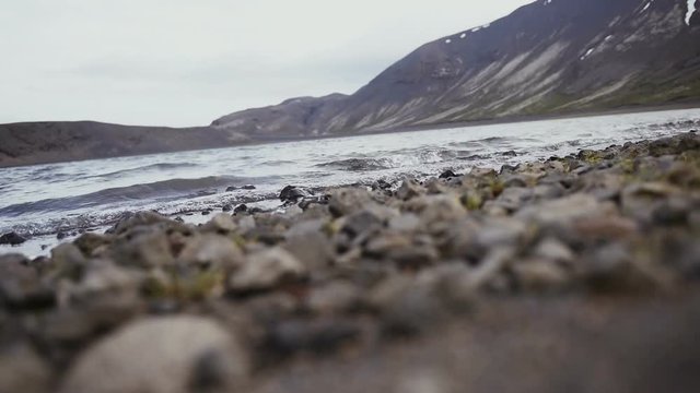 Sea waves on stones beach and mountains in Iceland
