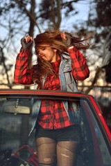 long-haired brunette girl dancing in a car