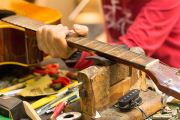  Technician repairs electric guitar,selective focus.
