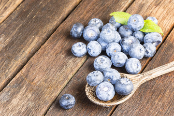 Blueberry and wooden spoon on old wooden table.Close up and top view.