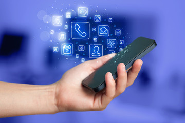 Hand holding smartphone with mobile app icons