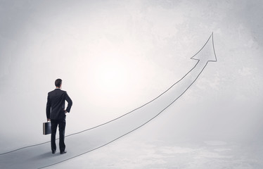 Business man standing on drawn arrow