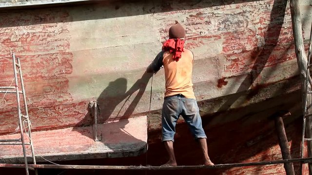 Boat Hull repairs/ A man using grinder in preparation for anti foul paint being applied