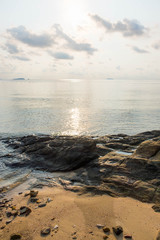 Fototapeta na wymiar Rock on the beach with calm sea during sunrise in dawn
