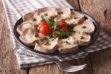 Italian cuisine: Vitello tonnato with capers, arugula, tomatoes close-up. Horizontal
