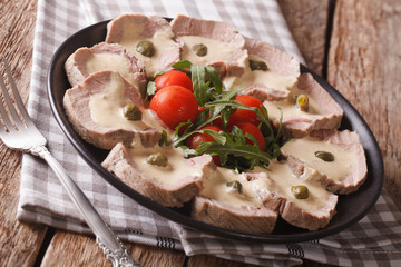 Italian Vitello tonnato with tuna sauce and capers close-up. horizontal
