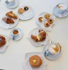 abundant Italian breakfast: cappuccino, croissants, pastries and fruit juice
