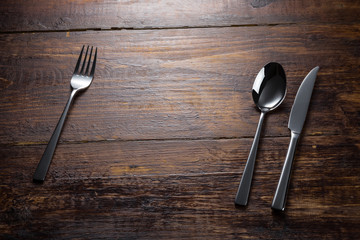 stainless fork spoon knife on the wooden table top