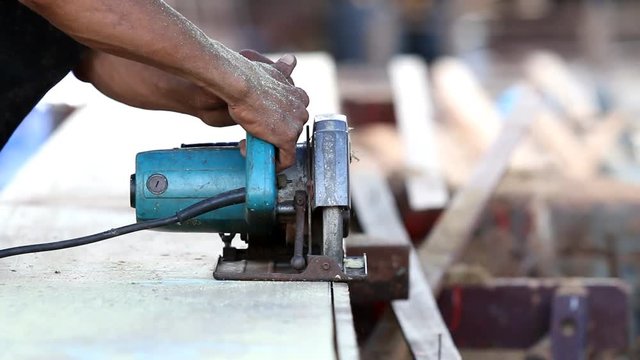 A man using a circular saw to cut the wood