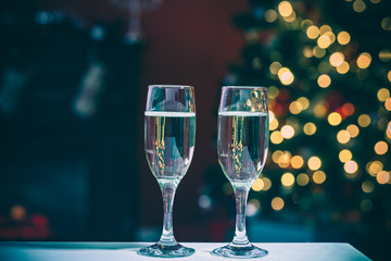 Two champagne glass on christmas bokeh background