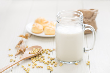 Obraz na płótnie Canvas Soy milk in a glass , soybeans on a white table