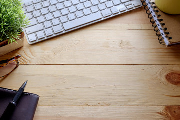 Office table with notepad, computer and coffee cup.