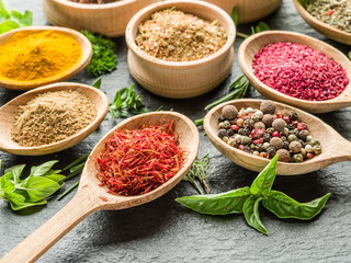 Assortment of colorful spices in the wooden spoons.