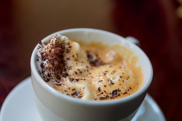 Cup of coffee on the wooden table.  with an ice creame and grated chocolate. Top view