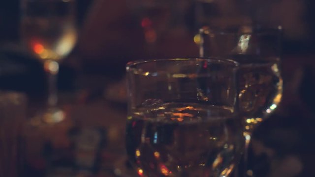 Restaurant or bar table with plate of appetizers and wine. Wine pouring in the glass. 4k. 3840x2160