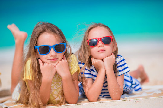 Adorable little girls during summer vacation. Kids on the white beach