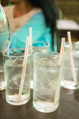 Glass of water with ice on a table in a restaurant.
