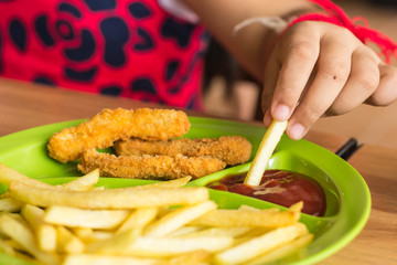 Little children eating french fries with ketchup