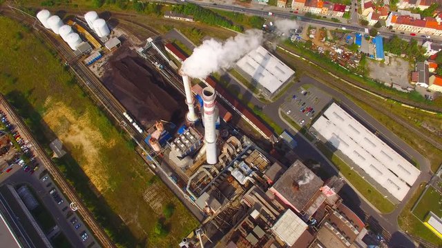 Camera flight over dustrial zone with fuming chimneys. Heavy industry from above. Steelworks and power plant in Pilsen, Czech Republic, European Union. 