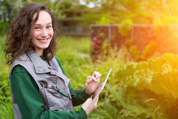 Portrait of a woman city public worker in a garden using tablet
