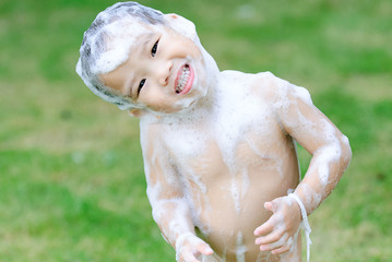 Shower boy in the garden with foam.