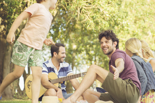Man at picnic watching children play