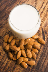 Almond milk with almond on a wooden table