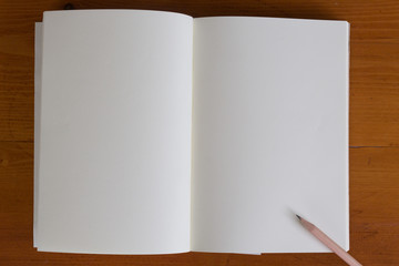 notebook with a pencil on wood table and copy space