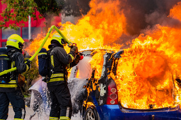 burning car with firefighters