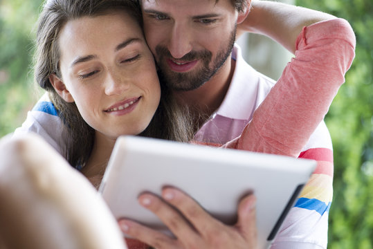 Young couple using digital tablet together outdoors