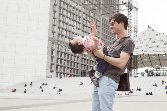 Father playfully holding baby son