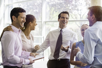 Colleagues having laugh together in office