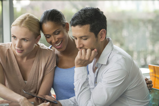 Man showing digital tablet to friends