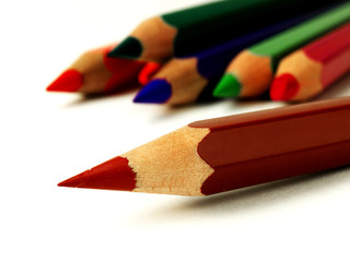 Obraz premium brown colored pencil in front of other pencils on white background, macro, shallow depth of field