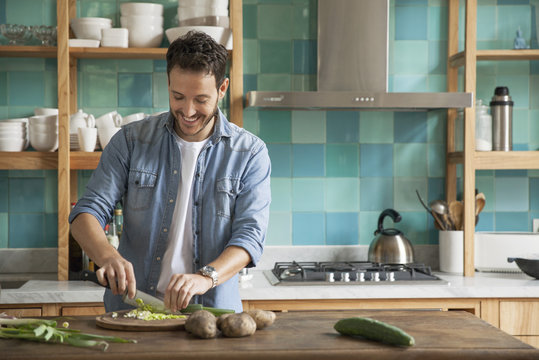 Man chopping up fresh ingredients in kitchen