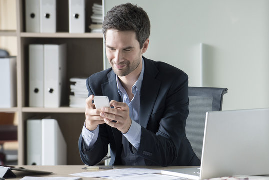 Businessman text messaging