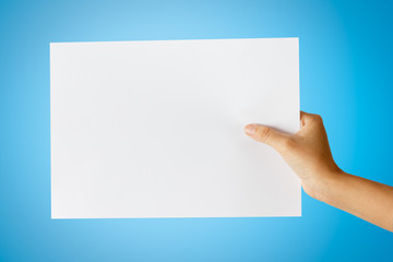 Fototapeta premium Hand holding paper isolated on blue,This picture has cut paths.