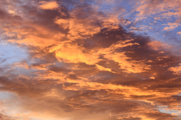 Naklejka na ściany i meble Fiery sunset with orange cloud and blue sky