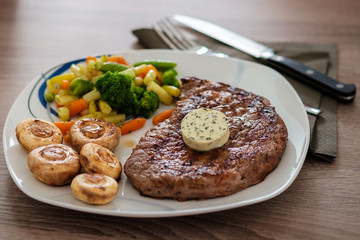 Steak mit Champignons, Gemüse und Kräuterbutter