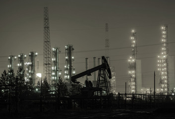 Fototapeta na wymiar Oil rig at the background of refinery by night. Oil and gas industry. Toned.