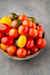 Tomatoes on the gray background. Colorful tomatoes, red tomatoes