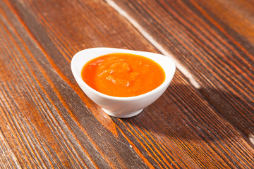 tomato sauce with a bowl on wooden table