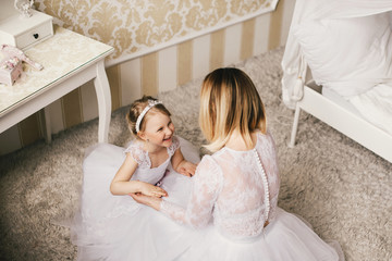Mother and daughter like brides in white dress.