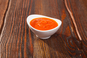tomato sauce with a bowl on wooden table