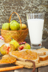 Homemade fig jam on slice of  bread and glass of milk for breakfast