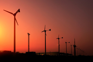 Obraz premium silhouette of wind turbine generating electricity on sunset.