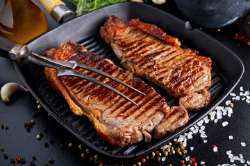 Fresh cooked meat Beef Steak Sirloin for two. in iron grilled pan with herbs.